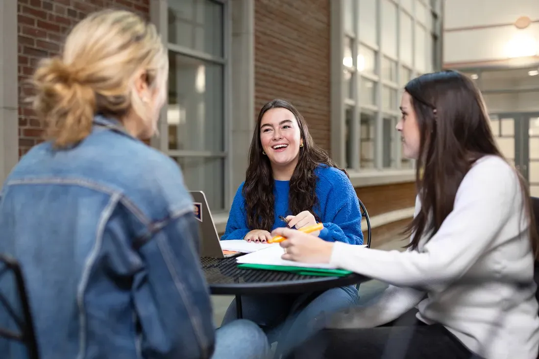 Student Katherine Waters sits at a table with friends.